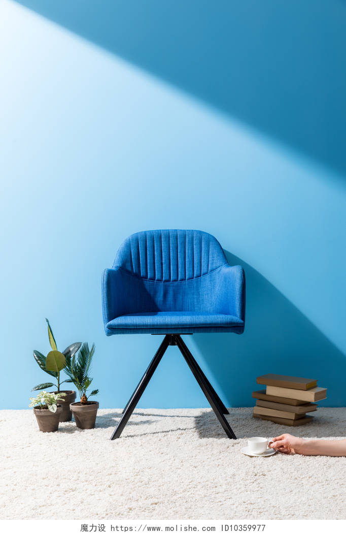现代风家居沙发椅装饰渲染图舒适的蓝色扶手椅与人拿着杯子咖啡在地板在蓝色墙壁前面